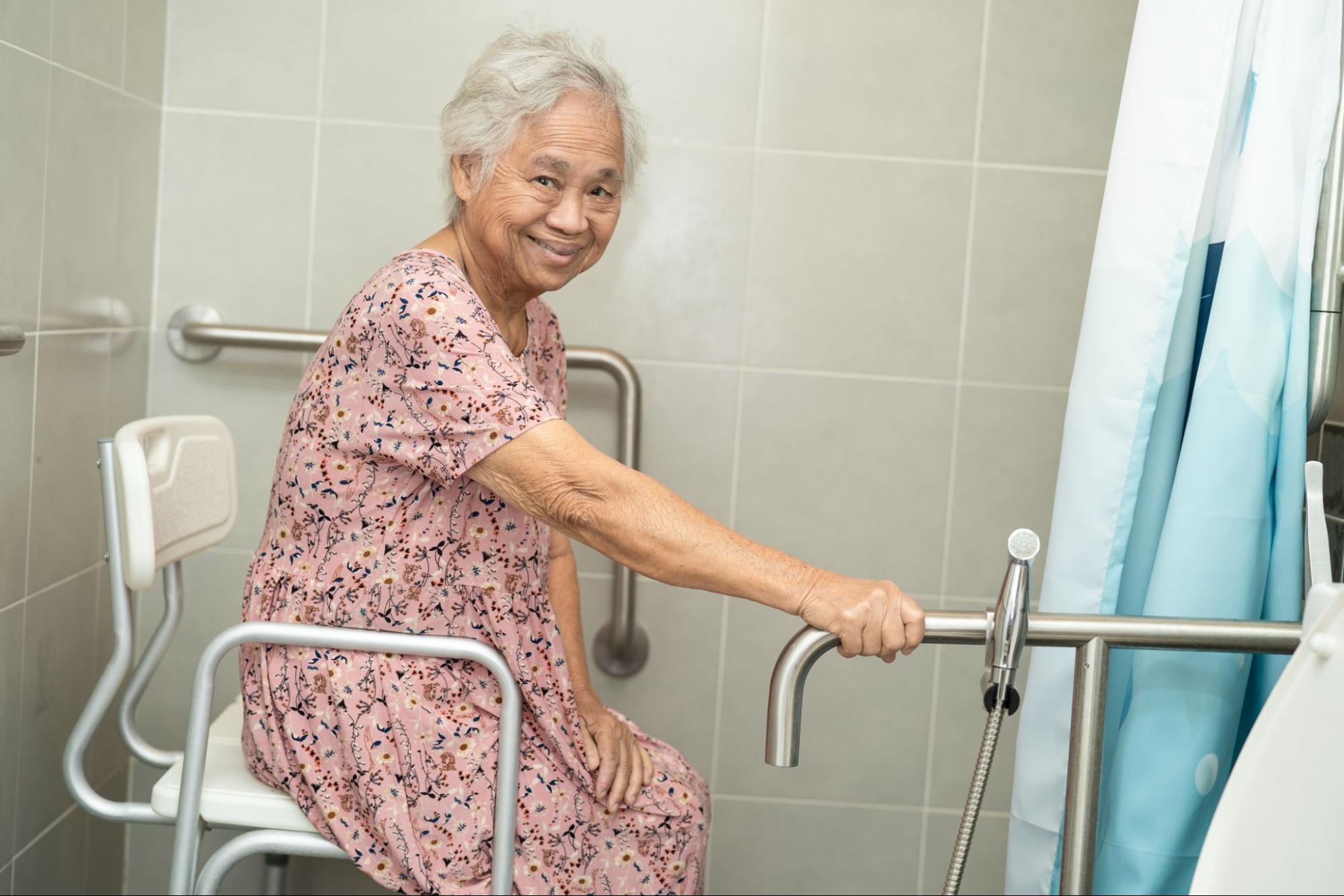 elderly-female-stroke-patient-with-home-modification-to-shower-with-handrails-and-shower-chair